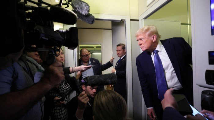 US President Donald Trump speaks to reporters aboard Air Force One