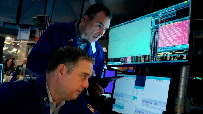 A pair of traders work on the floor of the New York Stock Exchange
