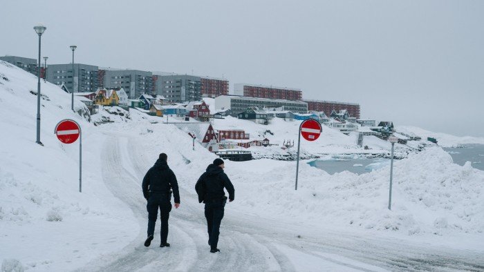 Two police officers walk along a street covered in snow in Nuuk, Greenland on March 24 2025