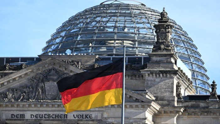 A German flag flutters in the wind in front of the cupola of the Reichstag building that houses the Bundestag, the lower house of the German parliament