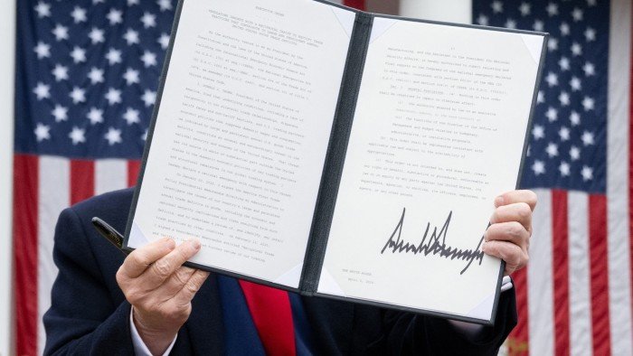 Donald Trump at the White House displays his tariff order after signing it