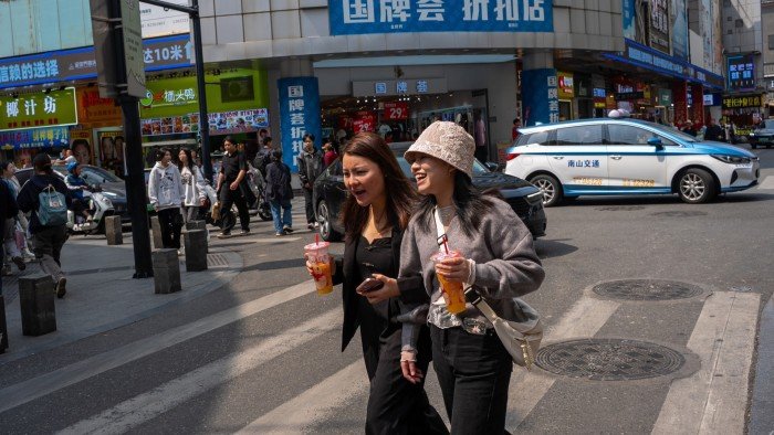 Pedestrians cross a street in Shenzhen, China